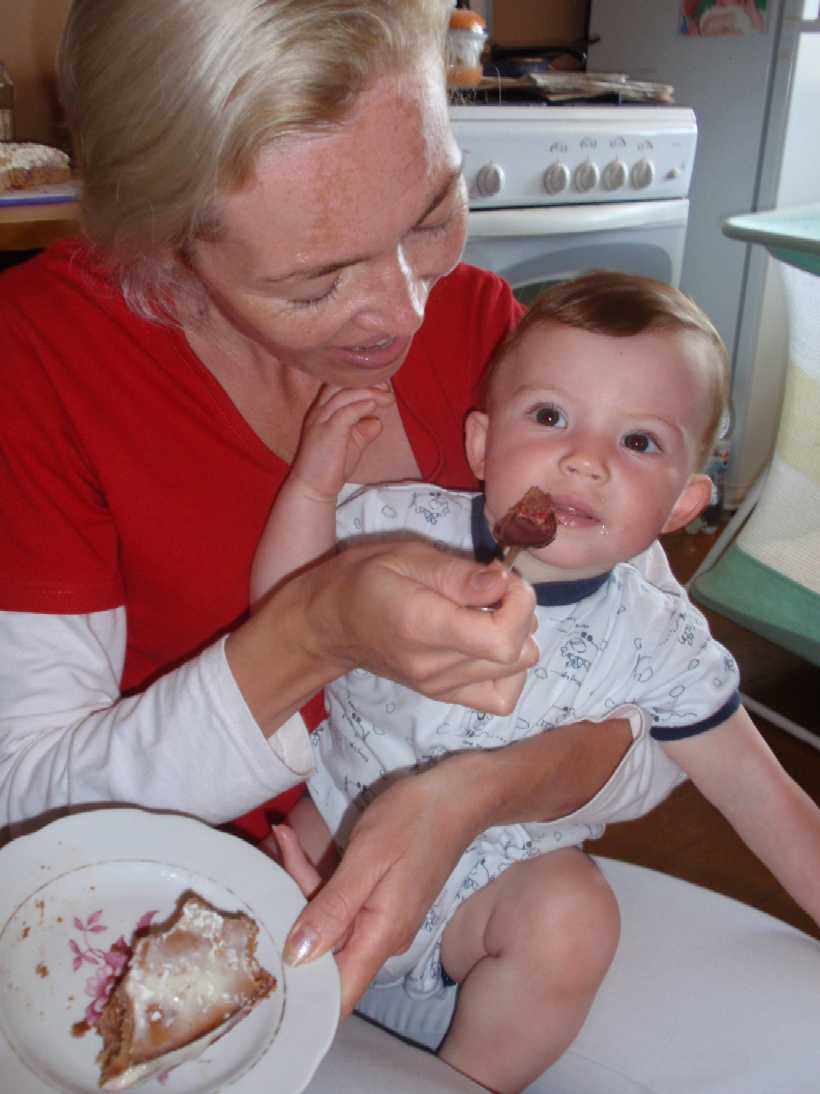 09  8 11  Robert, 1 yr, in Deana's arms eating cake 820x1094  P8110081